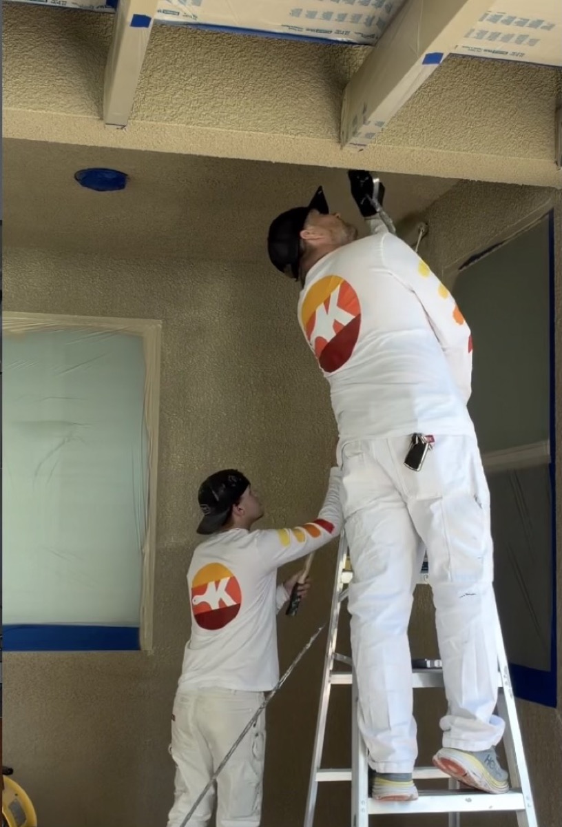 Kern Painting Pro crew painting an exterior patio ceiling from a ladder