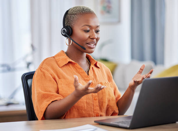 A smiling LvL Up Media sales associate wearing a headset, talking with a prospect from her home office